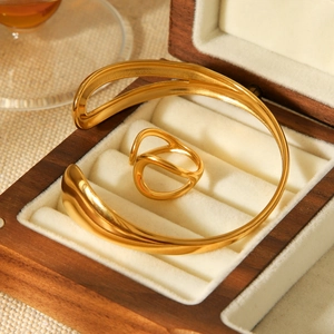 Detailed view of gold minimalist waterdrop bangle and ring set in a luxury wooden jewelry box