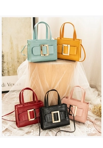 Macro detail of crocodile texture faux leather bags with signature metal square buckles