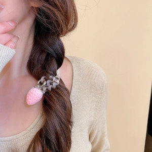 Vue détaillée d'un élastique à cheveux cordon de téléphone avec breloque fraise rose