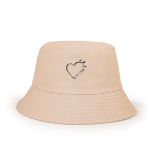 Détail du chapeau bob beige avec imprimé papillon et cœur sur tissu en sergé de coton