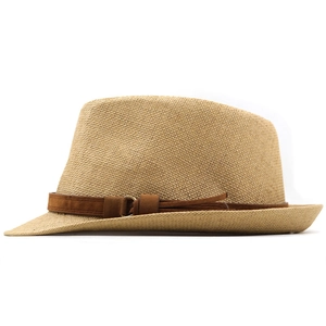 Detail of straw fedora hat with brown suede band, metal ring and tassel accents