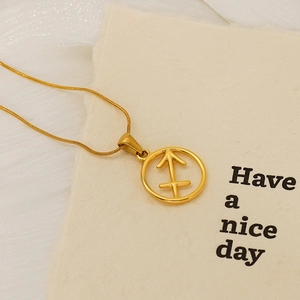 Macro shot of gold Sagittarius zodiac pendant necklace on beige card background