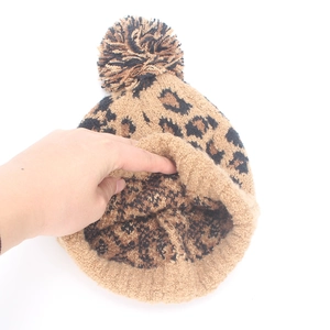 Leopard print knit beanie with pom-pom and thick fleece lining for winter warmth