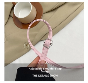 Détail de la bandoulière réglable en cuir rose avec boucle argentée sur le sac carré