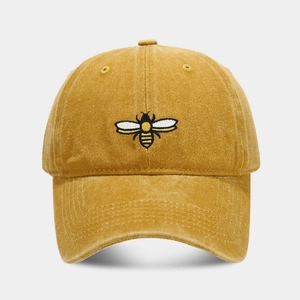 Close-up of mustard yellow washed cotton baseball cap with detailed bee embroidery