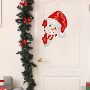 Christmas snowman wall sticker on white wooden door with festive holiday greenery decoration