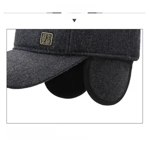 Detail view of winter baseball cap with foldable earflaps and metallic logo