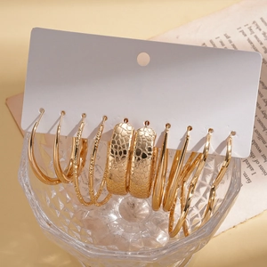 Detail view of 10-piece gold earring set with smooth and textured hoops on a display card