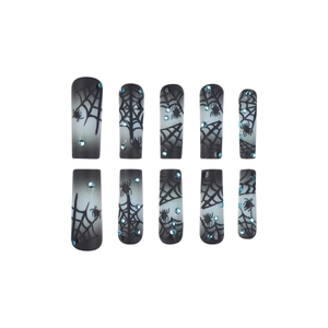 Halloween press-on nails with black spider web design and blue rhinestones on white background