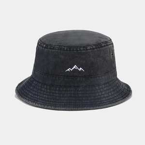 Detail of white mountain embroidery on washed black denim bucket hat with metal eyelets