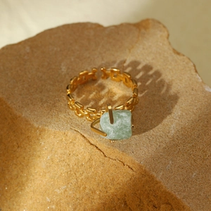 Adjustable gold titanium steel ring featuring a natural green stone on a rock