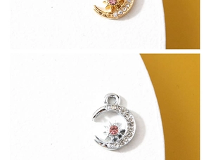 Detail of moon and star charms in gold and silver finish with inlaid rhinestones