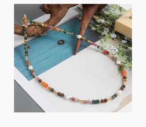 Close-up of colorful tourmaline and freshwater pearls on a handmade beaded necklace