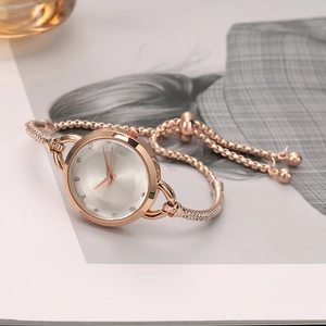 Detail of rose gold ladies' watch with small white dial and sparkling rhinestone bracelet