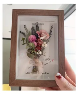 Detail of walnut wood 3D shadow box frame with preserved dried flowers and best wishes text