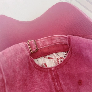 Deep pink washed cotton baseball cap featuring an adjustable metal buckle back closure