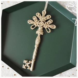 Close-up of golden glitter vintage key ornament on a dark green decorative tray