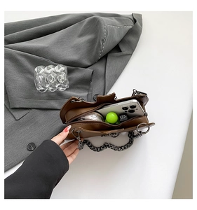 Detail view of the brown chain bag interior showing space for phone and makeup items