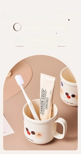 Détail d'un joli gobelet à brosser les dents de style crème avec poignée et visage