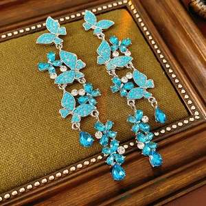 Detail shot of sparkling blue butterfly earrings with rhinestone fringes in a vintage frame