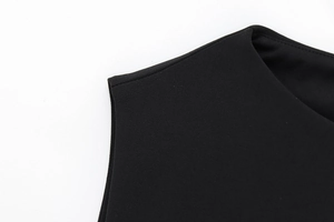 Close-up of neckline and shoulder stitching on black faux fur effect dress with belt