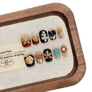 Faux ongles faits main avec relief floral doré vintage et motifs de crâne ambré