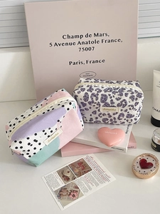 Detail view of stylish leopard and polka dot makeup bags with secure zipper closure