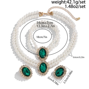 Detailed view of vintage jewelry set featuring faux pearl necklace and green gemstone earrings