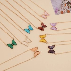 Colorful glass butterfly pendant necklaces with golden chain shown from a top view