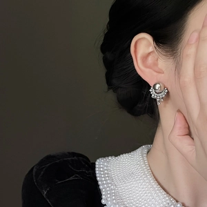 Detailed close-up of pearl and tassel earrings featuring sparkling crystal rhinestones