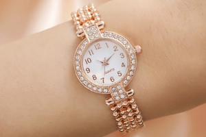 Detailed macro view of rose gold quartz watch with rhinestone bezel and multi-chain bracelet