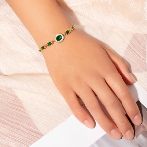 Detail of a vintage emerald green zircon bracelet in 18k gold plating on a wrist