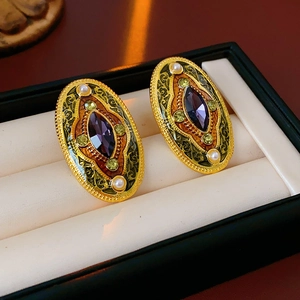 Macro shot of vintage style earrings with purple gemstones and pearls in a jewelry box