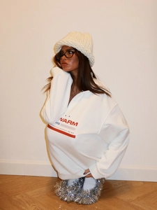 Detailed close-up of white half-zip sweatshirt featuring red WARM 15 vintage lettering