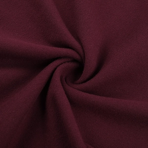 Macro shot of dark burgundy knit fabric showing soft texture and premium drape detail