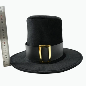 Detail view of a 20cm high black top hat with a velvet texture and golden buckle strap