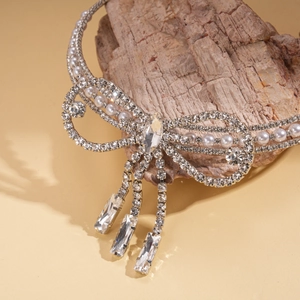 Detail view of silver bow necklace with faux pearls and sparkling crystal tassels