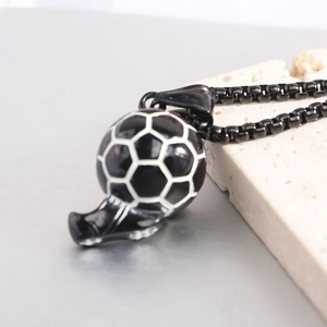 Détail d'un pendentif ballon de football noir et blanc sur une chaîne en métal