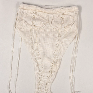 Detail von Häkel-Strickoberteil mit filigranem Strickmuster und Schnürung in Cremeweiß