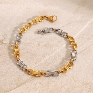 Détail du bracelet chaîne bicolore avec fermoir mousqueton sur fond de pierre naturelle