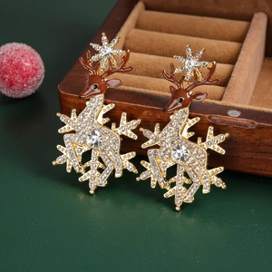 Detail of Christmas reindeer and snowflake earrings with rhinestones on a wooden box