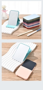 Macro shot of colorful portable folding makeup mirrors on a wooden desktop surface