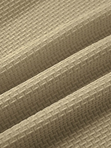 Macro shot of breathable beige waffle knit fabric texture on a slim fit sports T-shirt