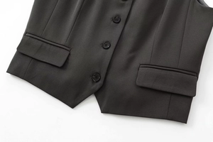 Détail du gilet noir montrant la texture en sergé, les trois boutons et la poche