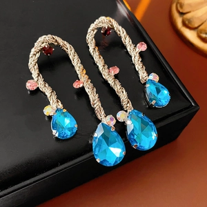 Detailed shot of vintage woven metal drop earrings with light blue waterdrop gems