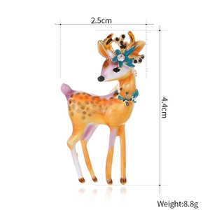 Broche cerf en émail peint avec accents orange et strass sur fond blanc épuré