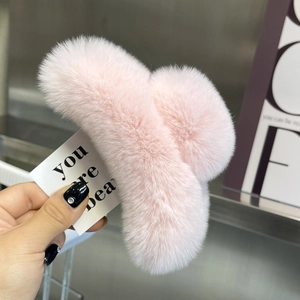 Close-up of pink faux rabbit fur hair claw clip showcasing soft plush texture and large size