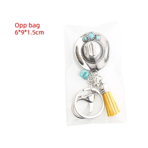 Detail view of a western cowboy hat keychain with turquoise beads and yellow tassel in OPP bag