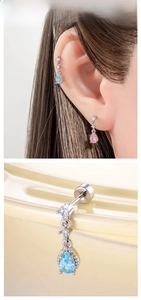 Macro detail of teardrop zircon dangle earrings with delicate silver chain and stud design