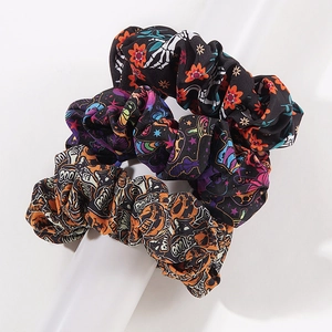 Three-piece Halloween scrunchie set with spooky patterns and BOO text on white stand